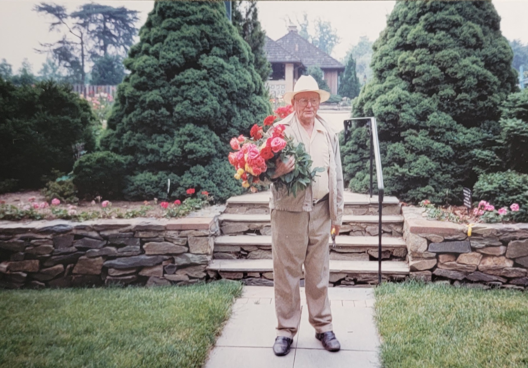Albert Behnke with a bouquet of roses in his backyard